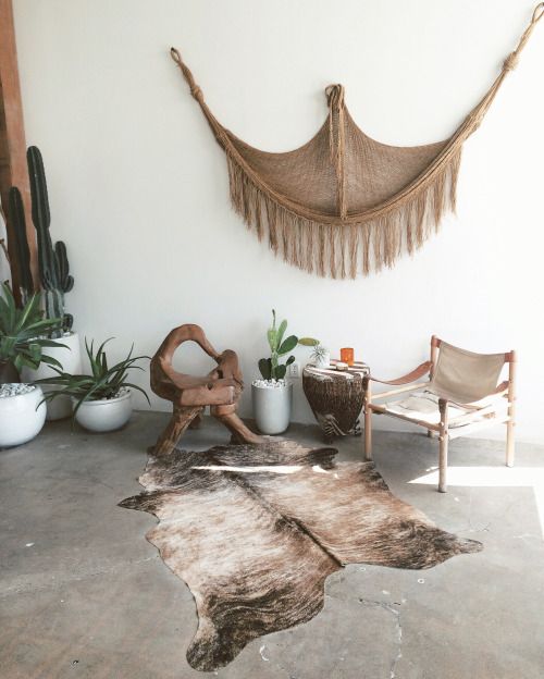 rustic interior with a large macrame, cacti and animal fur