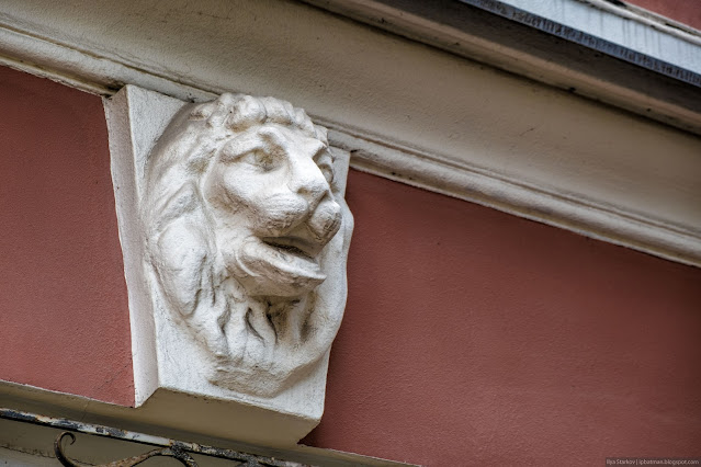 Барельеф головы льва на стене