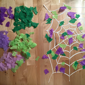 Sticking colorful pieces of torn up tissue paper to contact paper with a white spider web painted on it