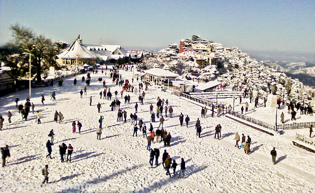 Shimla has been getting snowfall since 5th January 2012 and Sajeev has been capturing each moment of post-snowfall moments at various places around Shimla - Mall Road, Ridge ground, Scandal point, Lakkar Bazar etc. This year Shimla is getting heavy snowfall and some of the evidences can be seen in this Photo Journey from last week... Sanjeev Sharma with unknown Cameraman, Zee news, Shimla :)Sanjeev himself on Ridge Ground, while it's snowing on Ridge Ground, Shimla, Himachal Pradesh, India. You can see Christ Church on one corner of the Ridge and Shimla Library adjacent to it. Somehow Shimla is known by these two buildings. Yesterday only I saw fridge magnet at Connaught Place, Delhi with these two buildings carved on a marble piece to make a souvenir of Shimla, Himachal Pradesh. There were lot of other stuff form various cities of India like Jaipur, Varanasi, Maisoore etc.Here is a photograph with footmarks of people who were enjoying fresh snowfall on Ridge Ground and left for their homes.Although there are still few folks roaming around. Whole sky is covered with dense mist or clouds. The leading path is actually touching Mall Road, which is one of the main places people love to roam around in Shimla. buildings on left side are Goofa Restaurant and Bar by HPTDC and Gaitey Theatre, which was renovated last year only.Here is a closer look to Goofa Restaurant and Bar. One of the decent place to have dinner on Ridge Ground, although our experience of Goofa bar was not so good, when we were in University. But this is considered one of the decent places..Business in Snow... The famous Krishna bakers is closed but 100 Pipers and other brands of whiskey are available. And probably Rum would be more demand in such a lovely snow. Just notice the height of snow on the road... All these shops are located on lower part of the Mall Road...Another view of ridge Ground from an elevated boundary which leads towards Jakhu Temple, Shimla.Snow was on and off during last 10 days and yesterday there was heavy snowfall, which made people comment negatively about it. Till yesterday everyone from Shimla was putting happy and interesting statuses about Snowfall on facebook. But suddenly things changed yesterday when this snow started impacting lives of people in Shimla. For tourists, heavy snowfall can be good but for loacl folks it creates lot of problems at times. Water and Electricity supply is one of the main challenge during heavy snowfall hours. Notice the forest behind Mr. Sanjeev which are still white and these high deodars look amazing with snow on top of themPath created by Ambulance is being smartly used by these folks. vehicles are not allowed on Ridge Ground and Mall Roads.. Only Ambulance or police vehicles are allowed as and when required. Although many bollywood movies have shown vehicles flying on ridge ground. All that is done after special permissions from Shimla Authorities.Here is a a view of Shimla Ice Skating Club, which is located just below Lakkar Bazar, Shimla. This club is also visible from top of Indira Market on Ridge Ground. During December a national level event is organized, where lot of professionals come to this club for showing their Ice Skating performances. Even without ice these folks from Shimla can be seen on Mall Road and Ridge on  every Saturday :)Evening view of Ridge with spoiled snow... Place like Shimla are enjoyable either during fresh snowfall or without any snow. After 2 or 3 days of snowfall, snow melts or take a shape of huge pieces of ice which are risky to walk and dirty as well. During that time, snow in places are Kufri or Narkanda is more enjoyable. In fact, these days Skiing training is going on at Dhomri, Narkanda...Mr. Sanjeev, covered with multi-layered cloths and posing for a photograph against scandal point. Scandal point is a place from where two roads are diverted - one towards Ridge ground and other continues as Mall Road towards Shimla Town Hall and Gaiety Theatre.Gukli just stood up for this photograph, otherwise he must be busy in making snowman or playing snowballs :) ... Smile on his face is telling about the excitement about fresh snowfall in Shimla.Every year tourists come to Shimla during last week of Decemeber in a hope of Snowfall, but now timings have shifted a bit. For last few years, Shimla is getting snowfall in second week of January or towards end of first week.This year (2012), it was first time that some of the regions in Himachal got snowfall. Places like Hamirpur were also covered with white sheet of snow, although it remained only for few hours and then disappeared. At the same time various places of Kangra District got snowfall - Nagrota, Palampur, Dharmshala and Kangra town itself. Kangra Twon got snowfall after 52 years...Sanjeev is still waiting for his car to be uncovered of Snow Blanket... Try to imagine, how people in Shimla must be commuting to their offices and other places for some work... Conditions get worse in case of continuous snowfall for longer period of time.Many businessmen in Shimla make more money during tis season but at the same time, many folks with small setups loose lot of business due to heavy snow. I am sure that every weekend Shimla is getting lot of tourists from Punjab and Delhi...Sanjeev in perfect pose for this photograph with snow in the background :) (Shimla, Himachal Pradesh, India)Another amazing view of Ridge Ground covered with Snow and few folks walking on it... I still remember the day when I saw snowfall first time and we came to Mall Road for playing with snowballs... Everyone from our class was on Mall Road and whole day was full of fun and enjoyment....Sanjeev looks pretty happy and hopeful about this snowfall... Probably he is done with his walk on Mall Road and moving towards Press Club at Indira Market on Ridge ground of Shimla TownHere is last and wonderful photograph of this amazing Photo Journey by Sanjeev Sharma. Hope that snowfall comes with happiness and keep whole environment cheerful without any damage to anyone. And if you are amongst ones who have never seen snowfall, this is right time to plan your trip to Shimla and enjoy it.Thanks a Lot Sanjeev Sharma for such a Lovely Photo Journey with full of life photographs from last one week.