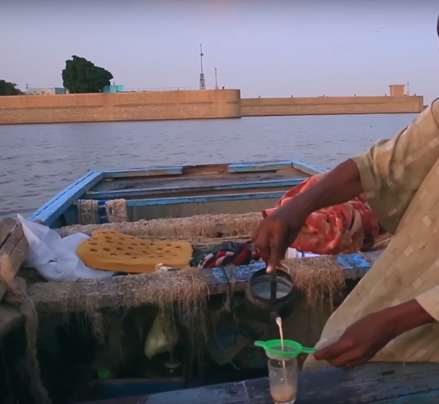 صور  السودان - خزان جبل اوليا - صياد على قاربه يعد حليبا بالشاي 