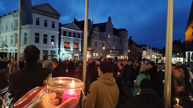 Rund 150 Menschen auf dem Marktplatz, eine Kerze im Vordergrund