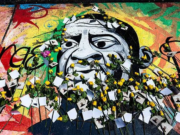 A mural of George Floyd is decorated with yellow roses and handwritten notes at George Floyd Square in Minneapolis, Minnesota, on May 23, 2025, during a tribute nearly five years after his death in police custody. Photo by Kerem Yucel/AFP