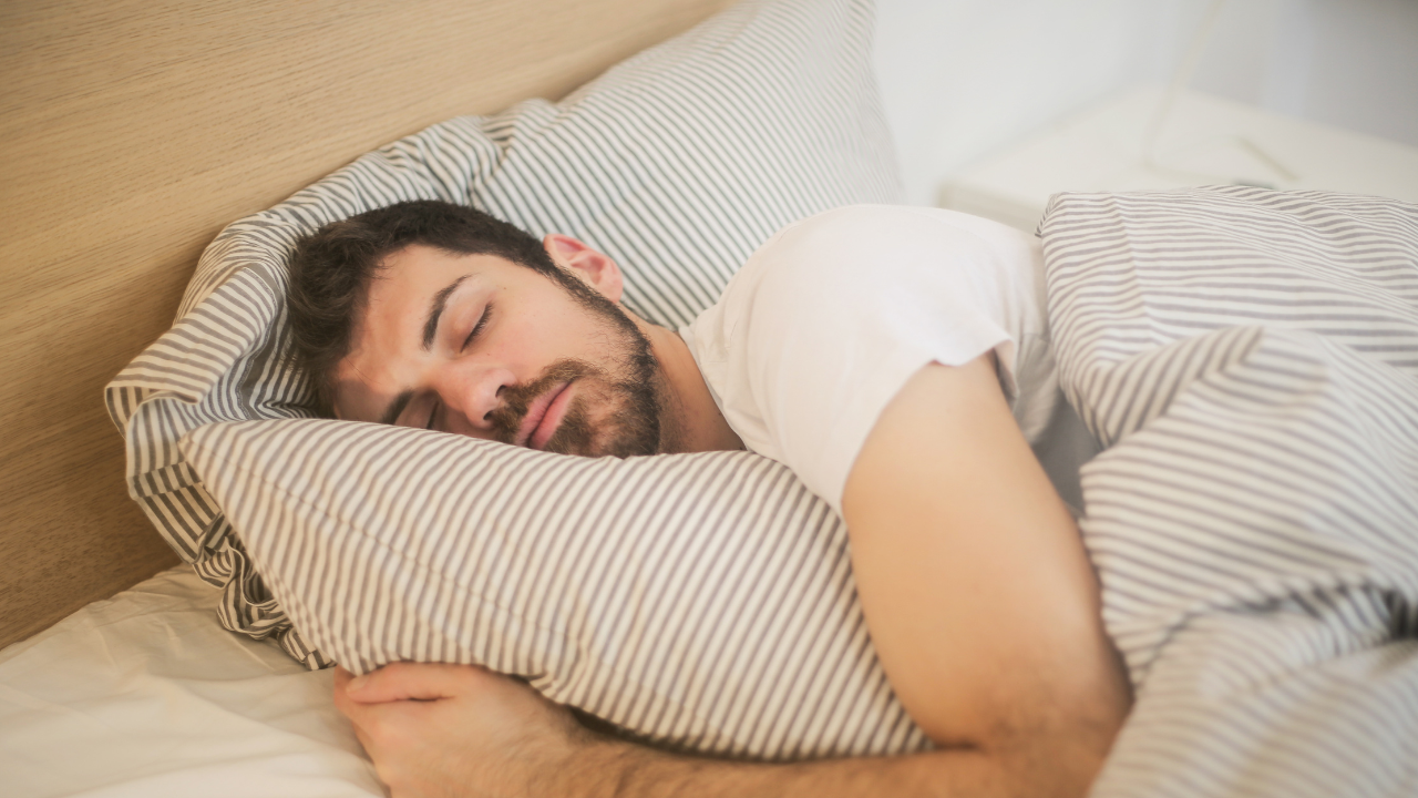 a person sleeping in a bed with their eyes closed