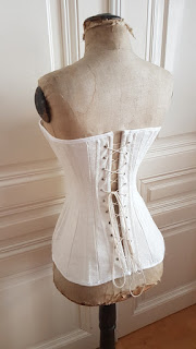 back/side view of the edwardian corset on an edwardian dress form