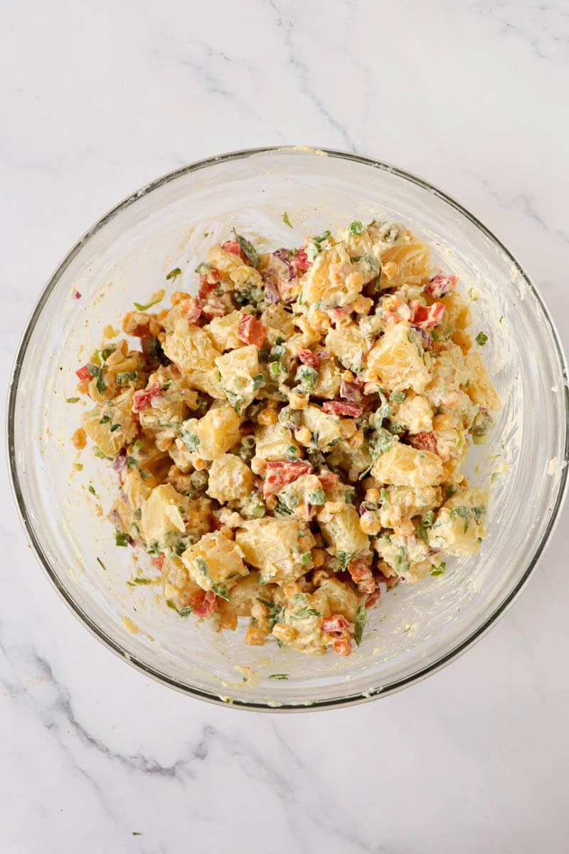 A bowl of mixed up potato salad.