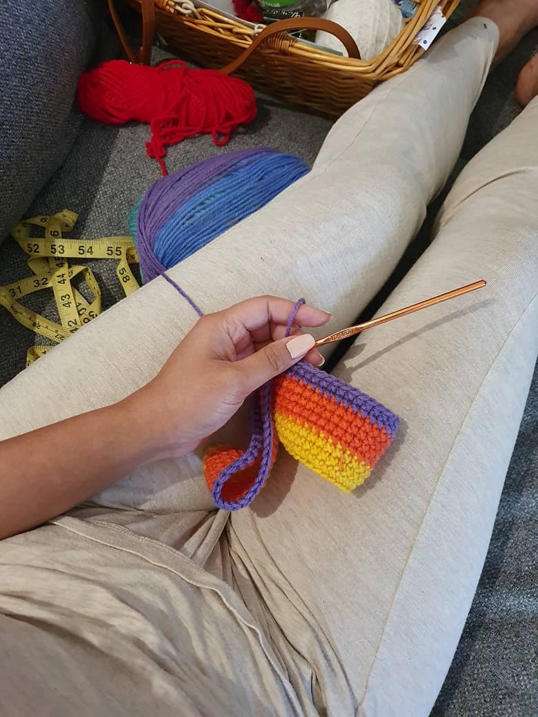 a woman holding a crochet wool indoor