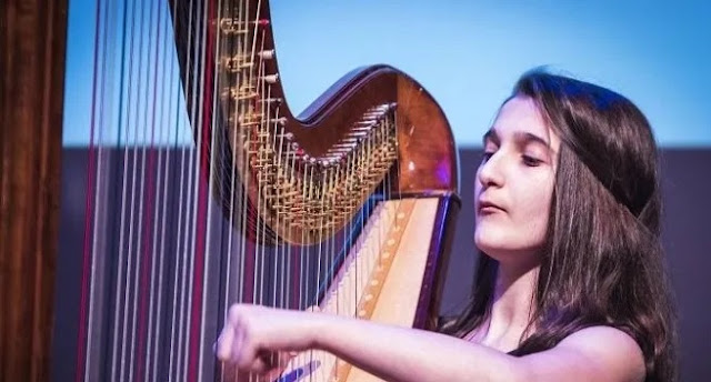 15-year-old Albanian artist Bujana Ameti performs on harp at the end-of-year concert in Belgium