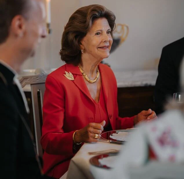 Queen Silvia wore a red blazer skirt suit. Gold necklace and gold brooch. Chanel shoes