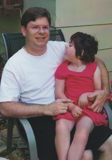 caregiver holding child with disabilities: Author and artist David Borden with his daughter, Savannah