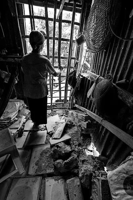 Bà NGuyễn Thị Kiệp 72 tuổi hốt hoảng trong căn nhà lá lụp sụp. Nền nhà bằng gạch tàu bật tung vì cây trốc gốc.