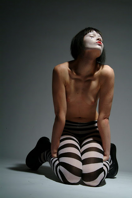 Mime, slim and topless, in light and shadow