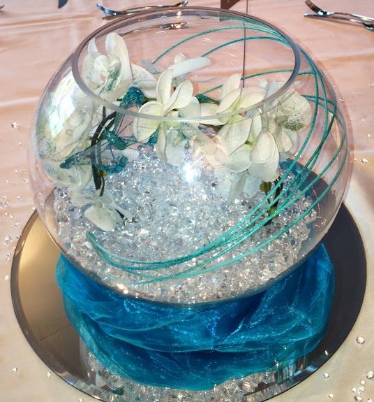 wedding table decoration with fish bowl containing aqua crystals, ribbons, beads