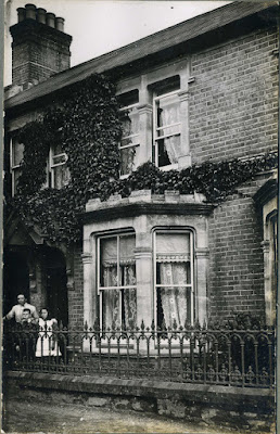 Lady and 2 children outside house