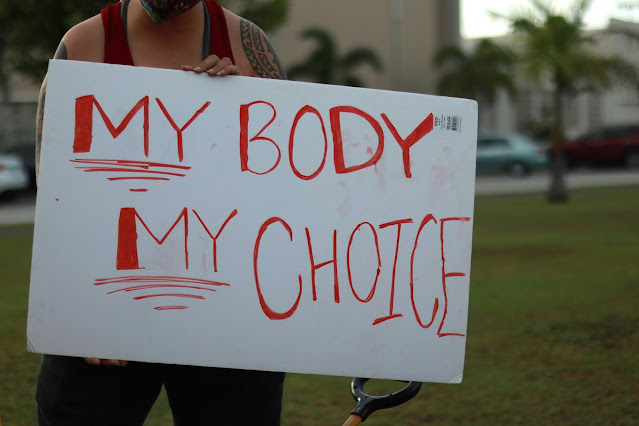 una donna mantiene un cartello con la scritta: "my body, my choice"