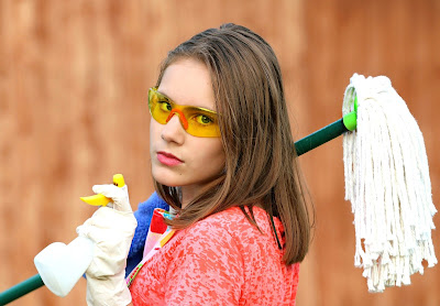 Mujer con fregona y spray de limpieza