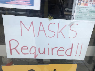 Sign that says "Mask Required" at door of small business