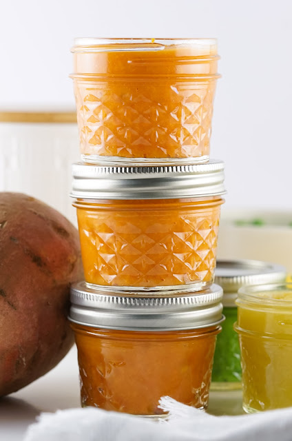 three jars of baby food stacked.