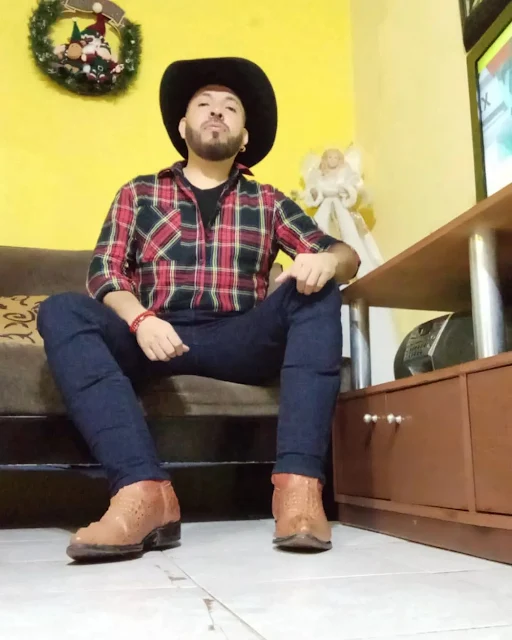 3/11 Stern faced South American man wearing blue jeans and orange cowboy boots sits in the superior POV