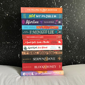 A stack of books on a white sheet against a black background with silver splatters.