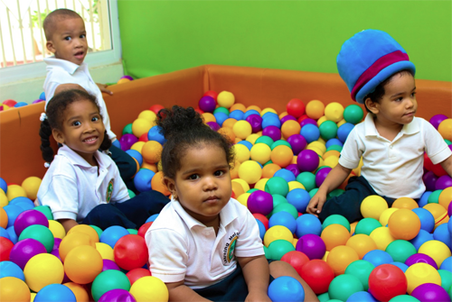 Niños jugando en una piscina de bolas de colores