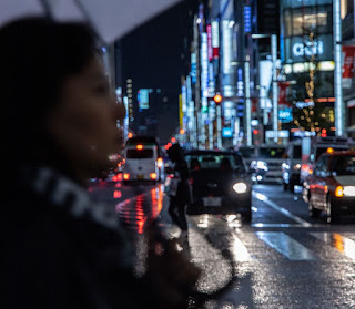 Woman with umbrella crossing street in rain