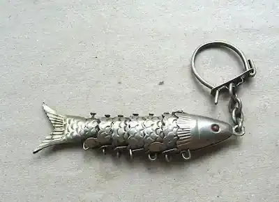من ألعاب الأطفال القديمة زمان: ميدالية مفاتيح على شكل سمكة معدنية لونها فضي أو ذهبي