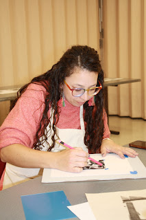 an art teacher works on a plate for printmaking