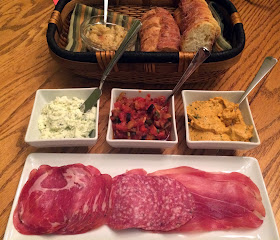 appetizer platter with various spreads and cured meats - with baguette