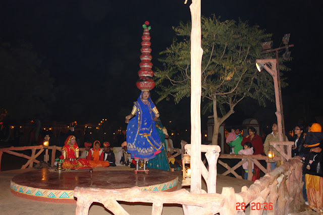 Photo of A dancer standing on metal tumblers in the open at Chokhi Dhani