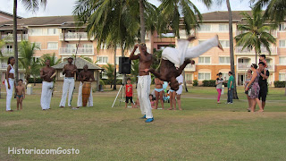  foto de um rapaz dando uma cambalhota em uma roda de capoeira 