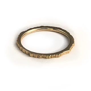 14K Yellow gold ring with a textured surface and high polish inside band. Shown on a white background