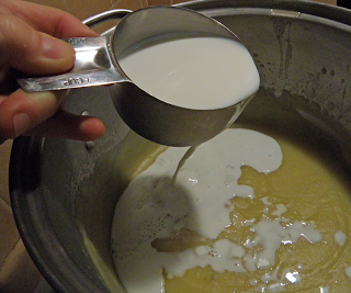 Hand Pouring Cup of Half and Half into Pureed Soup