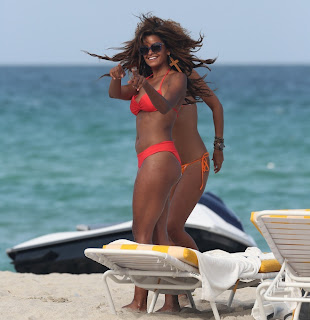 Claudia Jordan pointing at something on the beach