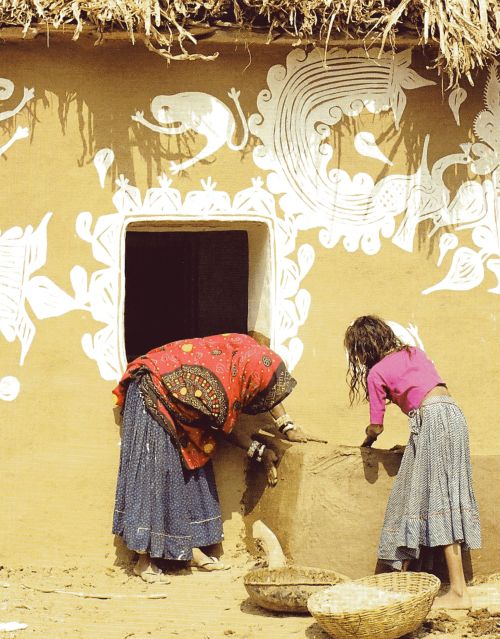 Meena women make mud wall