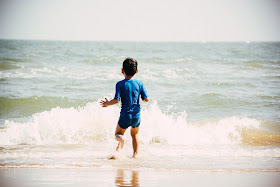 Niño corriendo para entrar en el mar