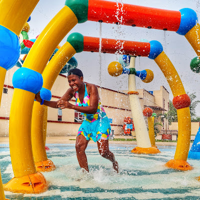 an adult playing at the splash pad at park vega waterpark