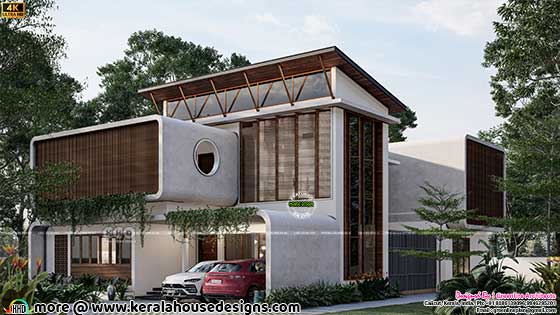 Side view of a distinctive 3400 sq.ft. tropical house featuring curvy flowing corners, a testament to the creative blend of modern architecture and tropical surroundings.