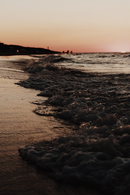 Wzburzone morze i zachód słońca na plaży w Juracie