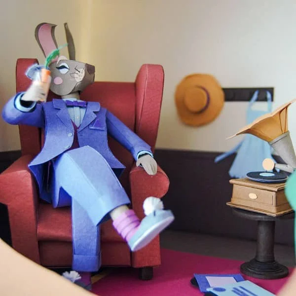 detailed diorama scene made of paper showing rabbit dressed in suit sitting in armchair near gramophone