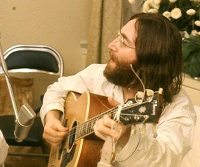 Foto de John Lennon cantando con su guitarra