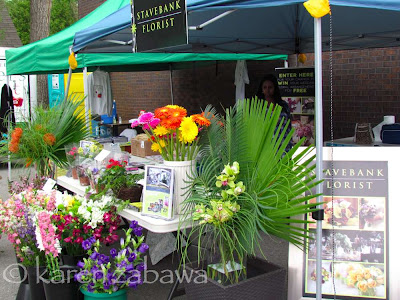 Colourful pots and vases of cut flowers and tropical plants surround Stavebank Florist stall.