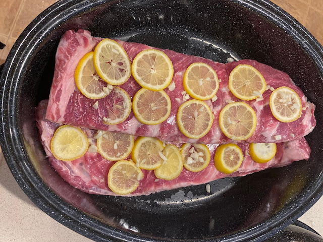 Uncooked ribs with lemon and garlic in baking pan