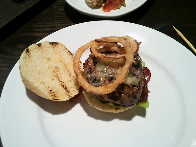 Opera Tavern's Iberico pork burger is topped with crunchy battered onion rings 