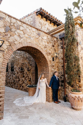 bride and groom holding hands around the corner at bella collina