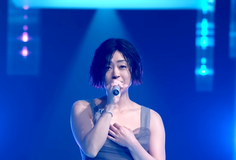 A screenshot of Hikaru Utada’s Music Awards Japan performance “Electricity” — featuring Hikaru in a short wet wig and a grey dress.
