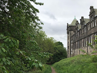 A photo showing part of the building of the old James Clark School with a dirt path running along the side of it at St Leonard's Crag in Edinburgh.  Photo by Kevin Nosferatu for the Skulferatu Project.