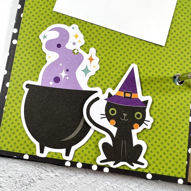 Halloween scrapbook album page with cauldron, black cat and witch's hat