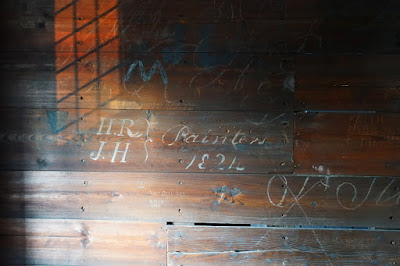 Graffiti on wood including 'HR, JH, Painters 1824' in flowing script.