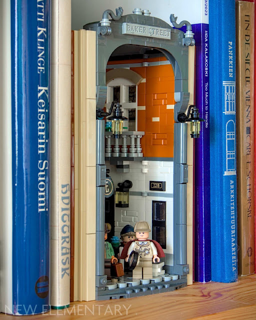 lego icons sherlock book nook set closed on a shelf among books, viewed from a slight side angle.